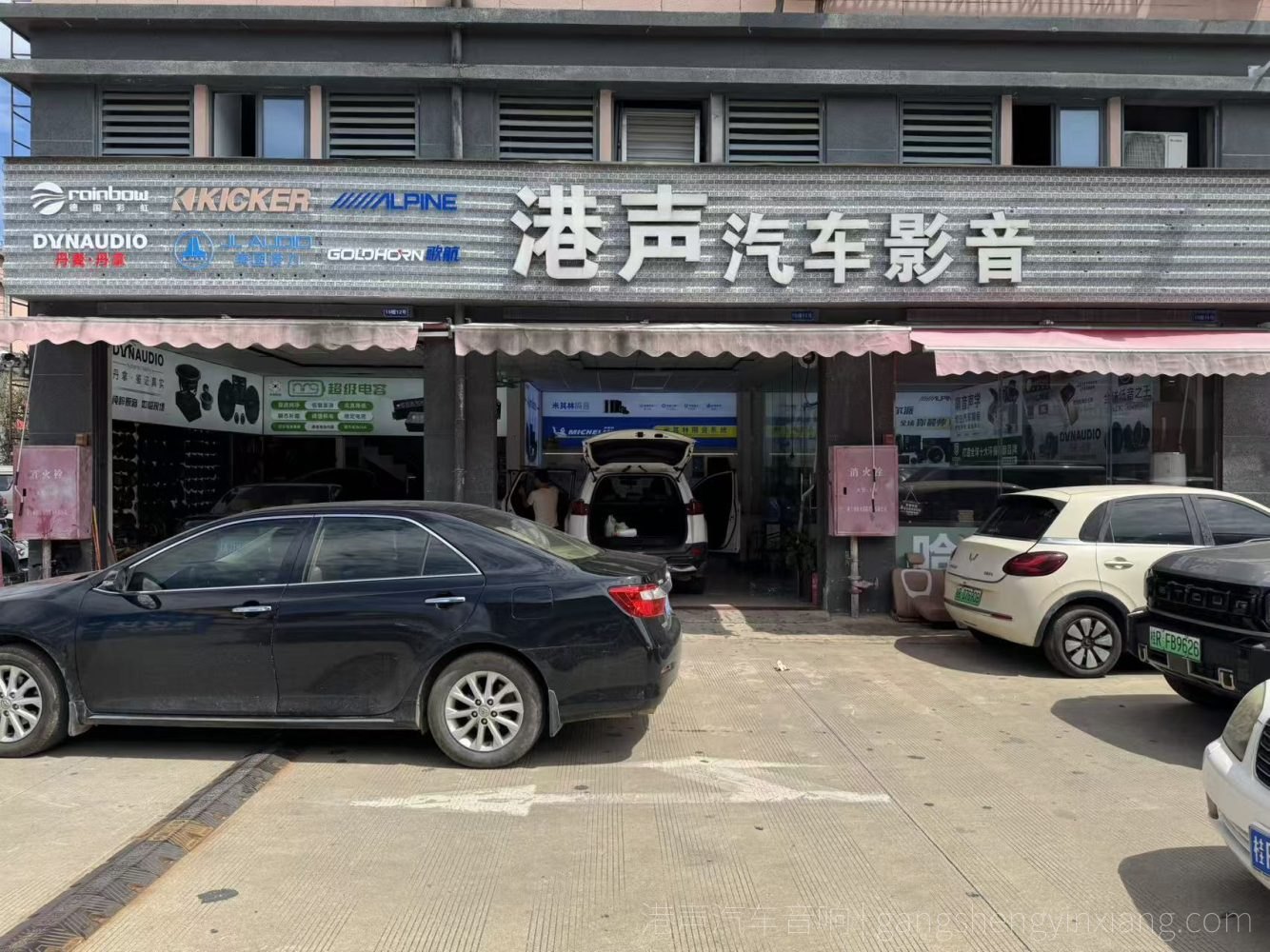 贵港港声汽车音响门店正面门头与施工车辆